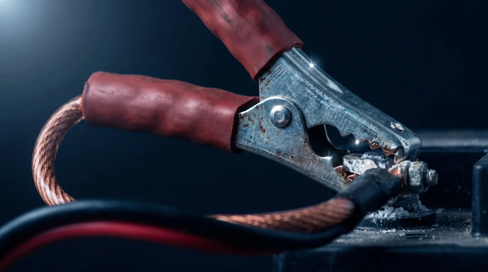 Jump start clamps attached to a car battery terminal