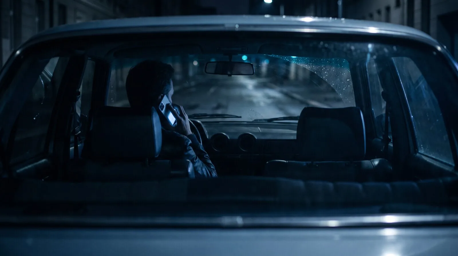 A driver using a phone beside a car