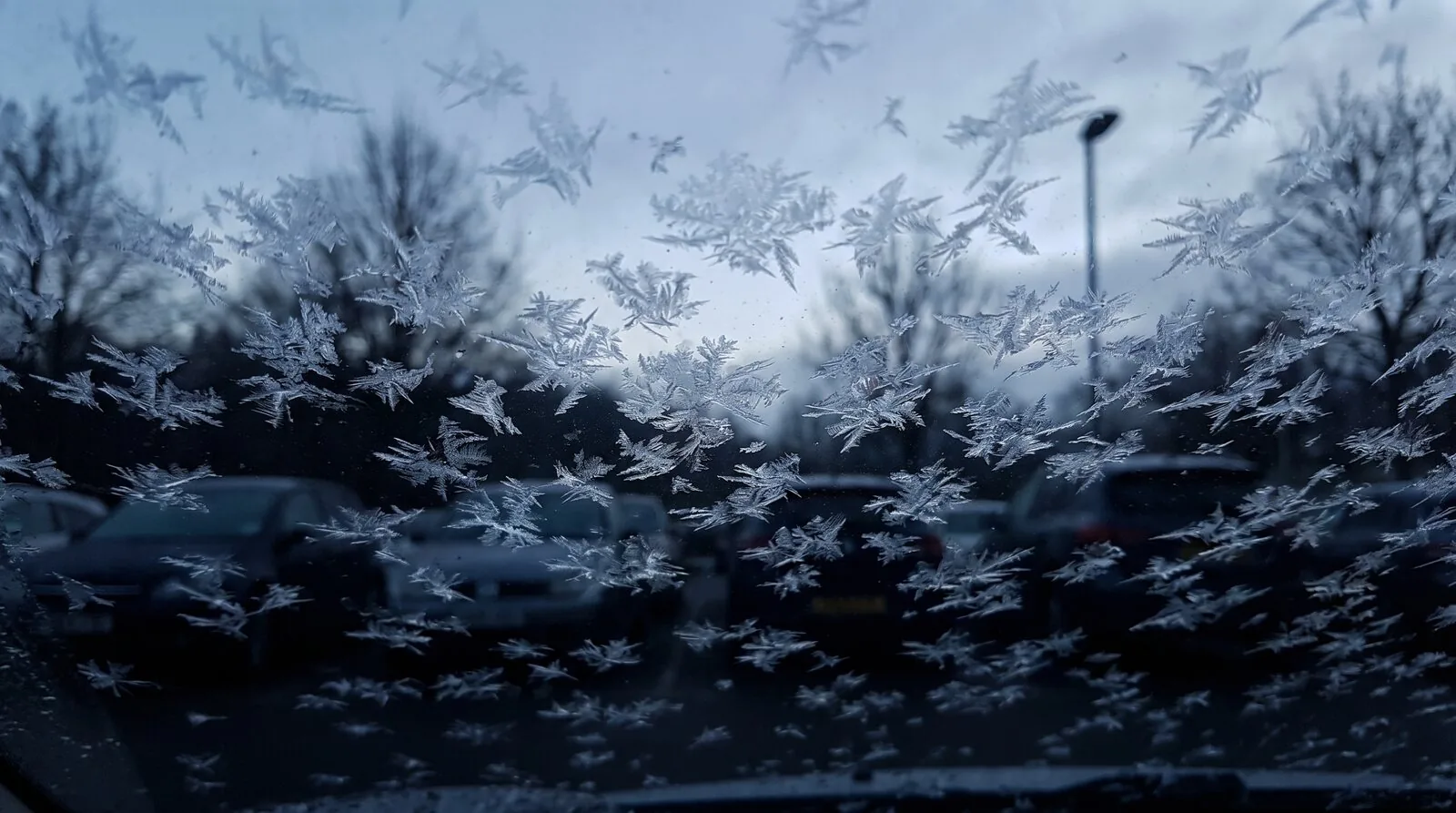 A car windscreen covered in frost on a cold morning